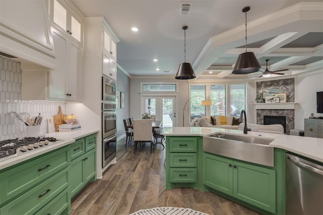 kitchen featuring light countertops, a sink, green cabinets, and stainless steel appliances