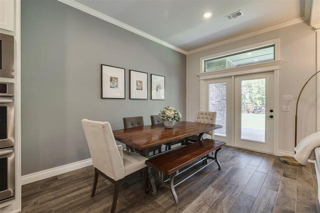 dining area featuring visible vents, baseboards, crown molding, and dark wood-style floors
