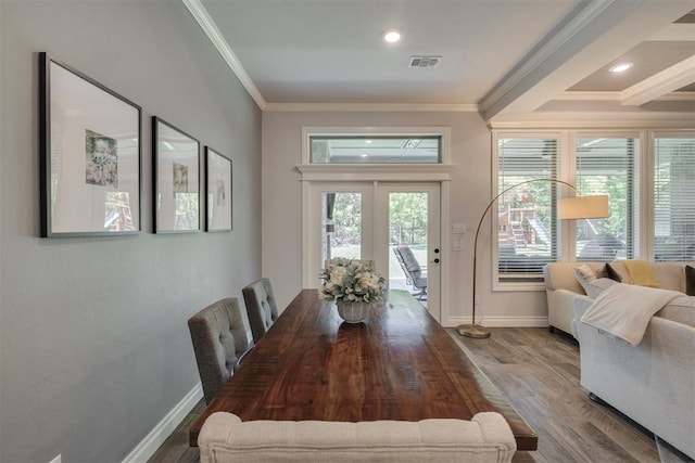 dining area with crown molding, baseboards, wood finished floors, and visible vents
