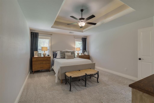 bedroom featuring baseboards, light colored carpet, ceiling fan, and a raised ceiling