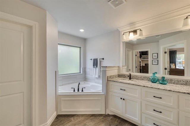 bathroom with visible vents, vanity, recessed lighting, a bath, and a spacious closet