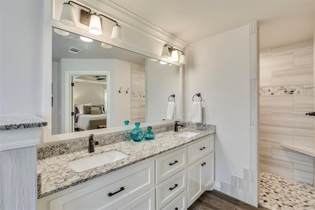ensuite bathroom featuring a sink, tiled shower, ensuite bath, and double vanity