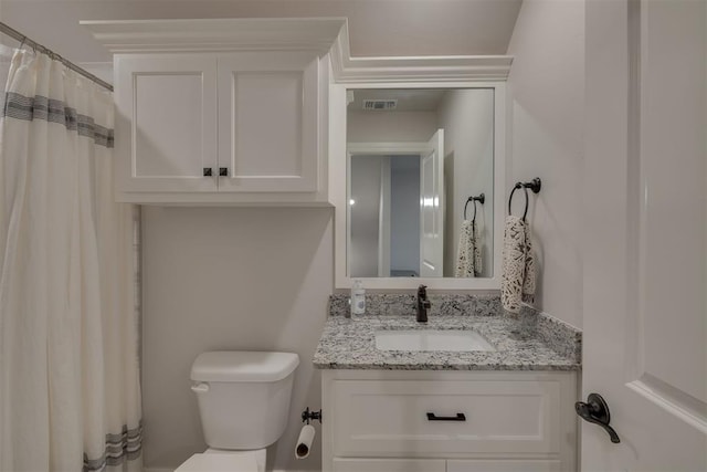 bathroom with vanity, toilet, and visible vents