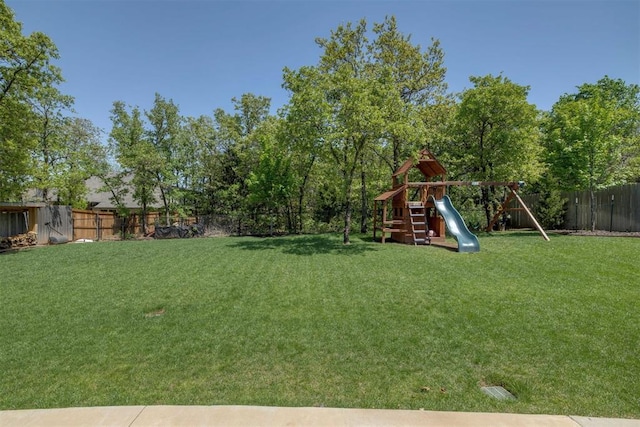 view of yard featuring a fenced backyard and a playground