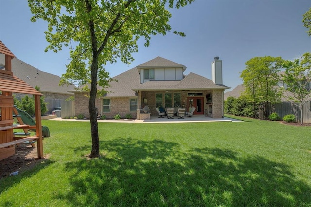 back of house with a fenced backyard, a chimney, brick siding, a patio area, and a yard