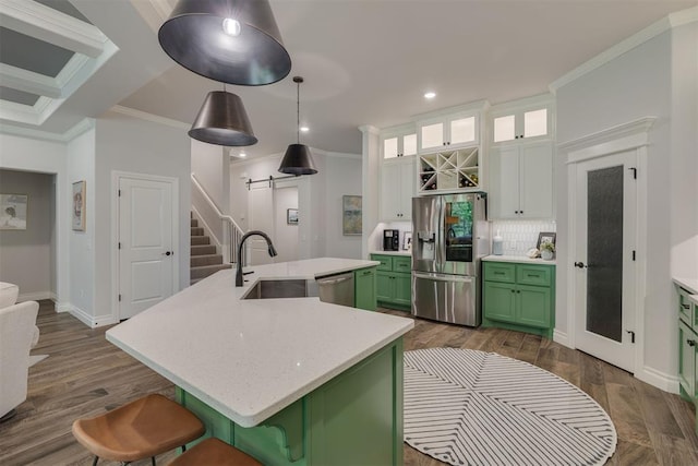 kitchen with crown molding, green cabinetry, a sink, stainless steel appliances, and backsplash