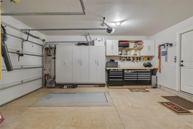 8817 Arya Rd, Edmond, OK 73007 - garage featuring a garage door opener and a workshop area