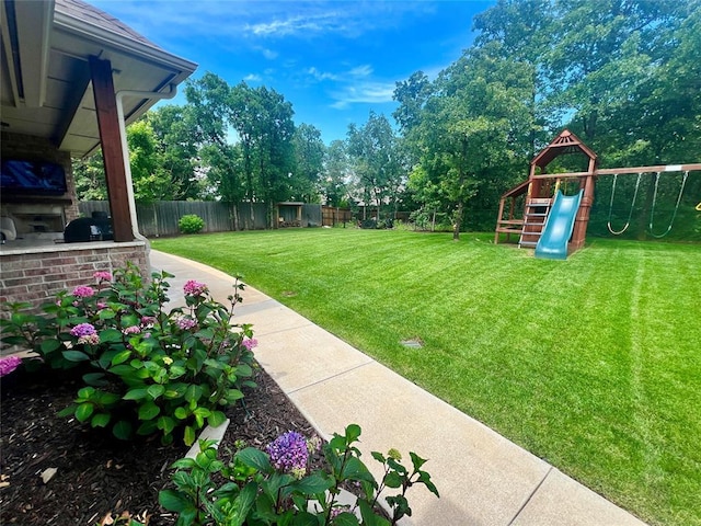 8817 Arya Rd, Edmond, OK 73007 - fenced backyard featuring a playground and exterior kitchen
