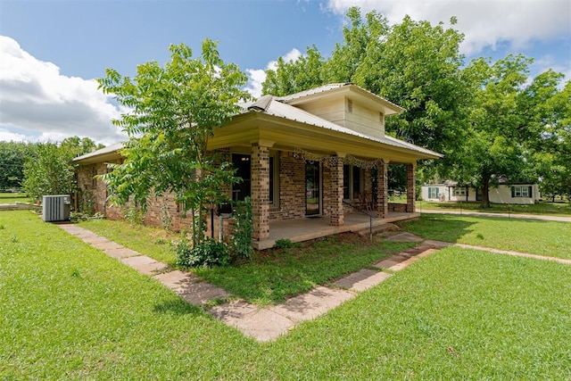 801 Lincoln St, Ryan, OK 73565 - view of property exterior featuring central air condition unit, covered porch, a lawn, and brick siding