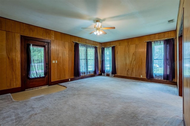801 Lincoln St, Ryan, OK 73565 - spare room with a ceiling fan, wood walls, and carpet floors