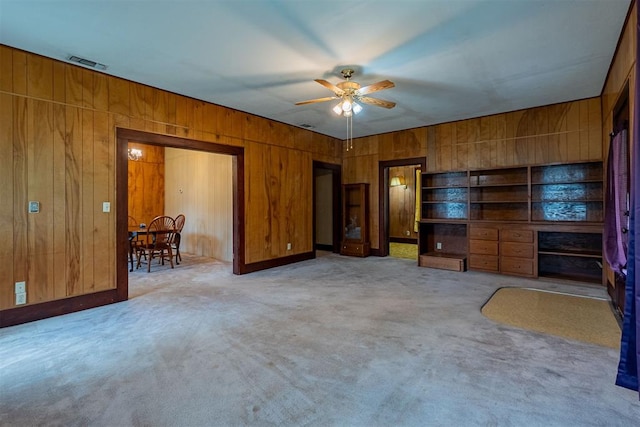 801 Lincoln St, Ryan, OK 73565 - living room featuring ceiling fan, wooden walls, and light carpet