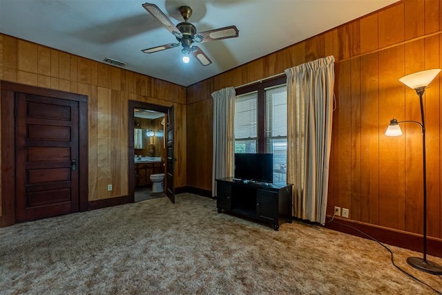 801 Lincoln St, Ryan, OK 73565 - living area with ceiling fan, carpet, wood walls, and baseboards