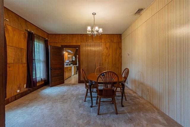 801 Lincoln St, Ryan, OK 73565 - dining room featuring a chandelier, carpet, and wood walls