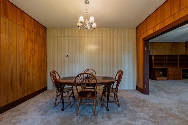 801 Lincoln St, Ryan, OK 73565 - dining area featuring carpet flooring, a chandelier, and wooden walls