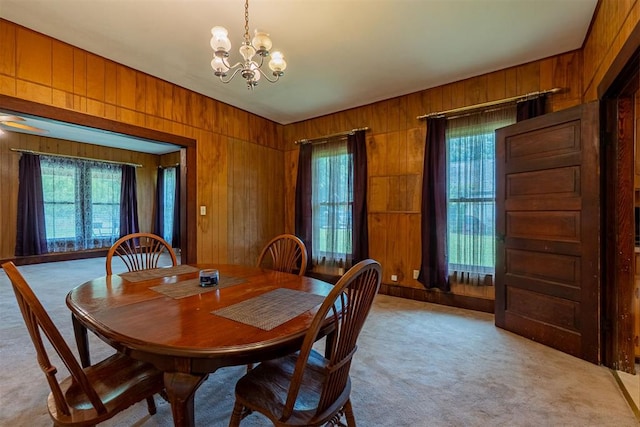 801 Lincoln St, Ryan, OK 73565 - dining room with light colored carpet, wood walls, plenty of natural light, and a chandelier