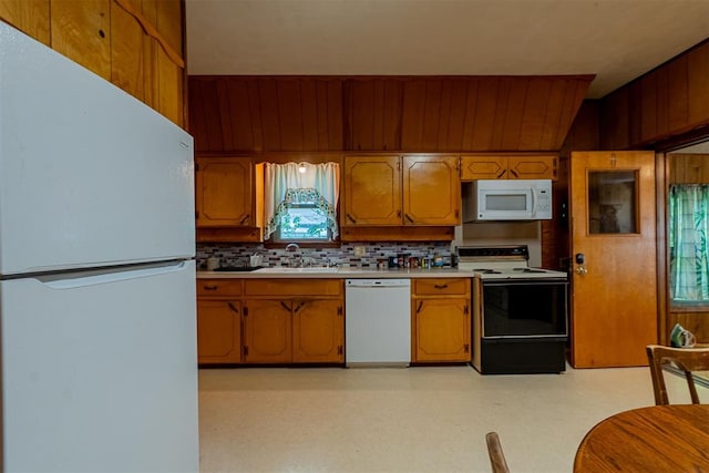 801 Lincoln St, Ryan, OK 73565 - kitchen with white appliances, light countertops, tasteful backsplash, brown cabinetry, and a sink