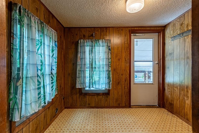 801 Lincoln St, Ryan, OK 73565 - foyer entrance featuring wood walls, a textured ceiling, and light floors