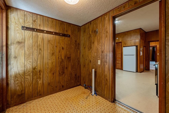 801 Lincoln St, Ryan, OK 73565 - spare room featuring wood walls, a textured ceiling, and baseboards