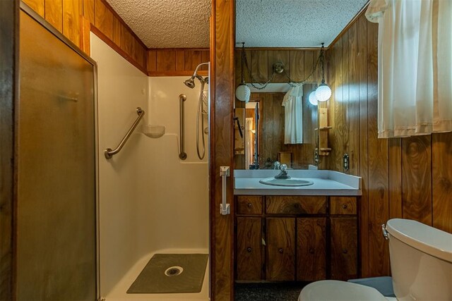 801 Lincoln St, Ryan, OK 73565 - bathroom featuring a stall shower, toilet, a textured ceiling, vanity, and wood walls