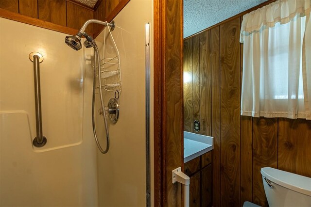 801 Lincoln St, Ryan, OK 73565 - full bath with a walk in shower, toilet, and wood walls