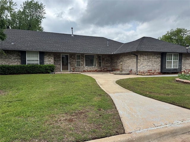 single story home with a front lawn, roof with shingles, and brick siding