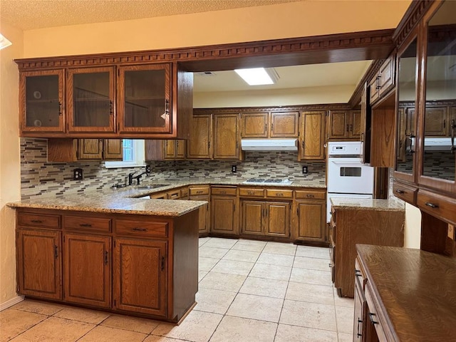 kitchen with light tile patterned flooring, light stone counters, decorative backsplash, and white double oven