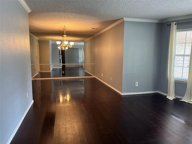 unfurnished room with a chandelier, hardwood / wood-style flooring, a textured ceiling, and crown molding