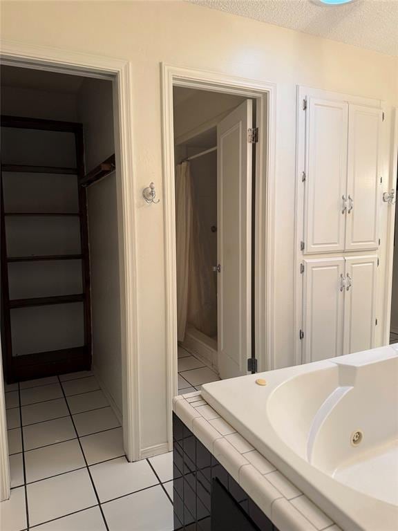 bathroom with curtained shower, tile patterned flooring, and a textured ceiling