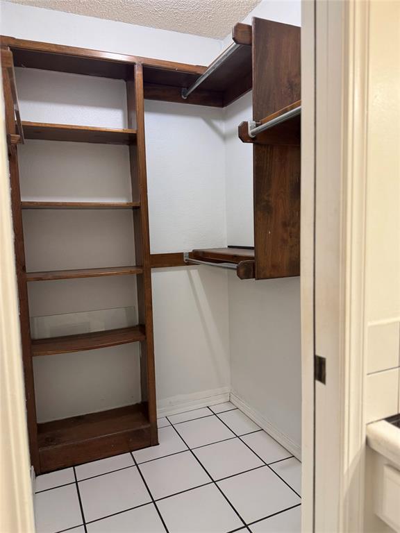 spacious closet with light tile patterned floors