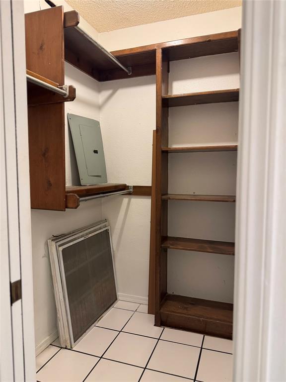 walk in closet with light tile patterned floors and electric panel