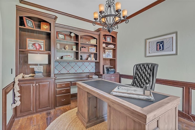 office space featuring an inviting chandelier, crown molding, and wood finished floors