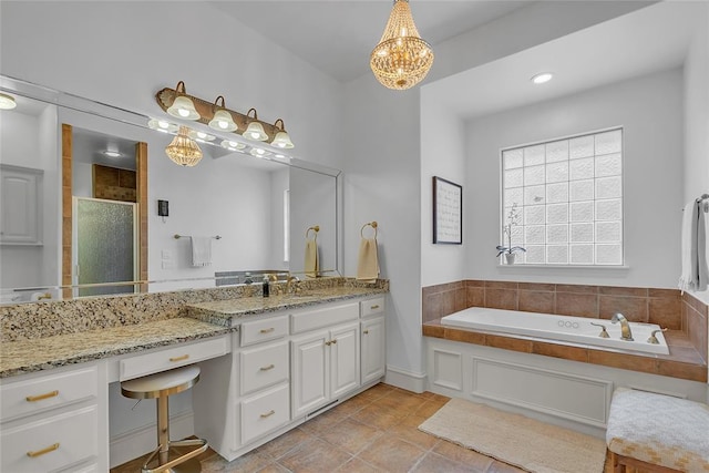 bathroom with a notable chandelier, tile patterned flooring, vanity, a bath, and a stall shower