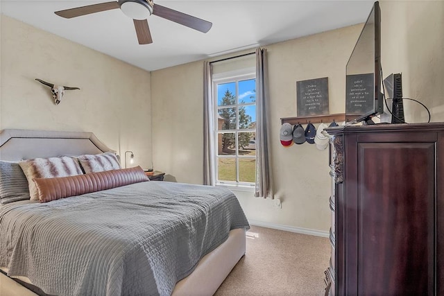 bedroom with light colored carpet, baseboards, and ceiling fan