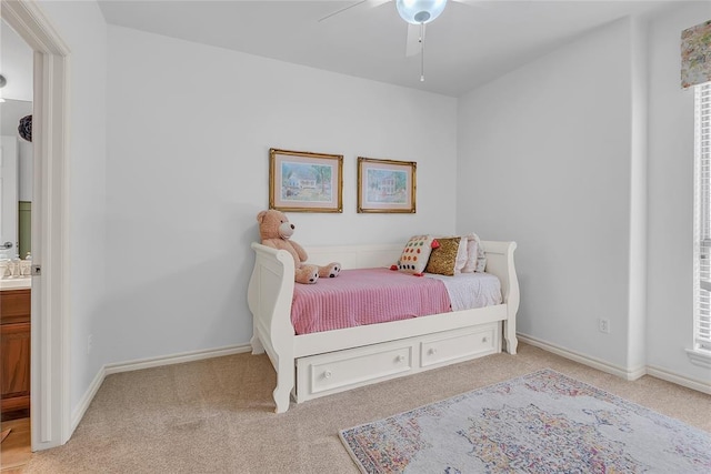 carpeted bedroom featuring baseboards and connected bathroom