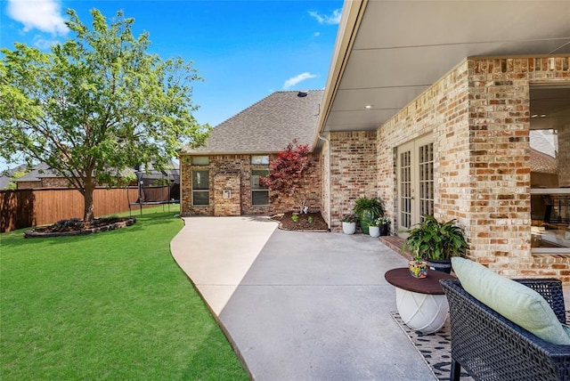 view of patio featuring fence, french doors, and a trampoline