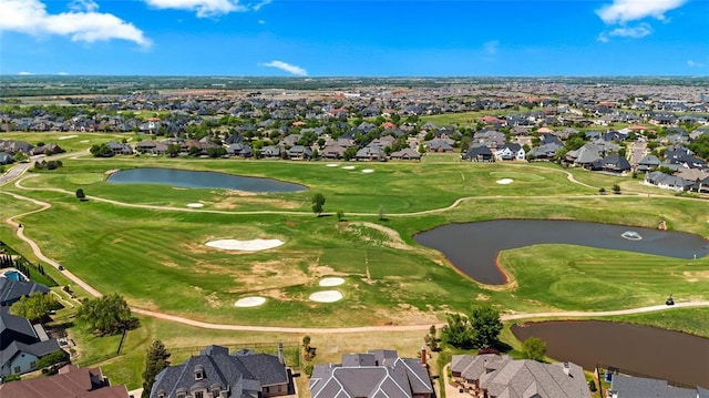 drone / aerial view featuring a residential view, view of golf course, and a water view