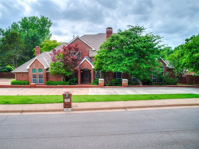 3601 Rena Dawn Ln, Edmond, OK 73013 - traditional home featuring brick siding, a front lawn, and a chimney