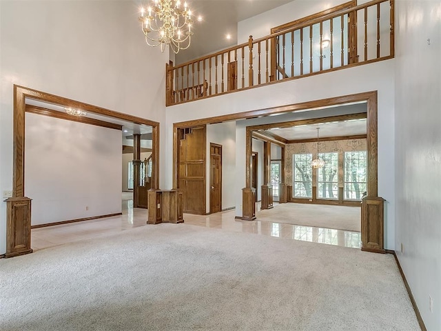 3601 Rena Dawn Ln, Edmond, OK 73013 - unfurnished living room featuring an inviting chandelier, carpet, baseboards, and a high ceiling