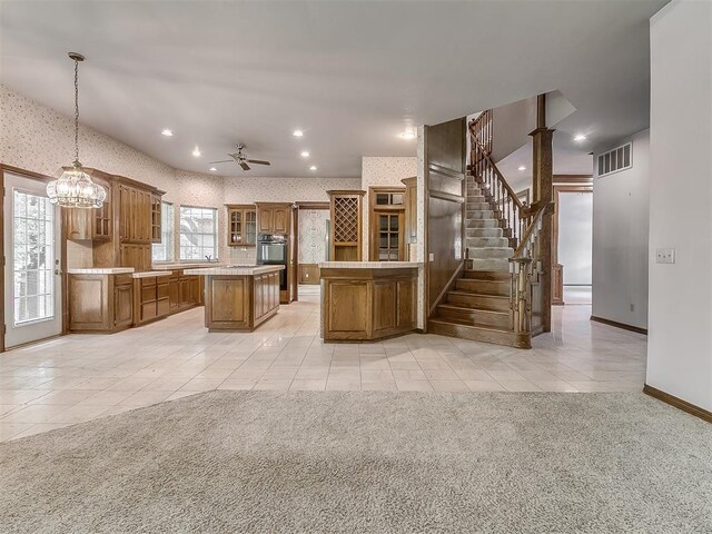 3601 Rena Dawn Ln, Edmond, OK 73013 - kitchen with light tile patterned flooring, brown cabinetry, a center island, visible vents, and glass insert cabinets