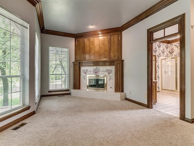 3601 Rena Dawn Ln, Edmond, OK 73013 - unfurnished living room with crown molding, visible vents, baseboards, light colored carpet, and a tiled fireplace