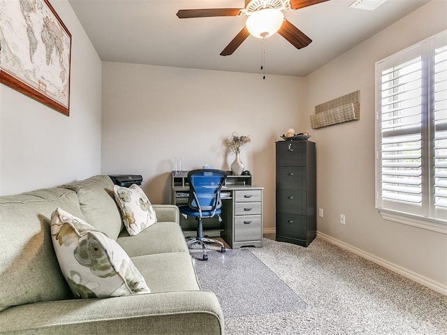 carpeted office space with baseboards, ceiling fan, a healthy amount of sunlight, and visible vents