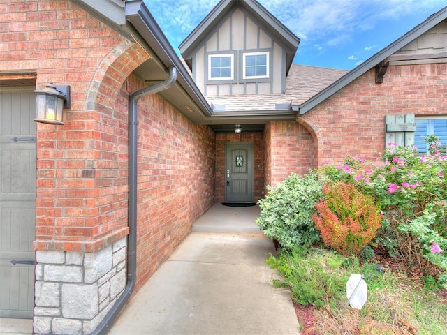 property entrance featuring brick siding and a shingled roof