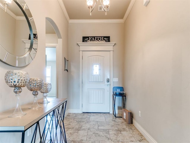 entrance foyer with baseboards, arched walkways, crown molding, and a notable chandelier