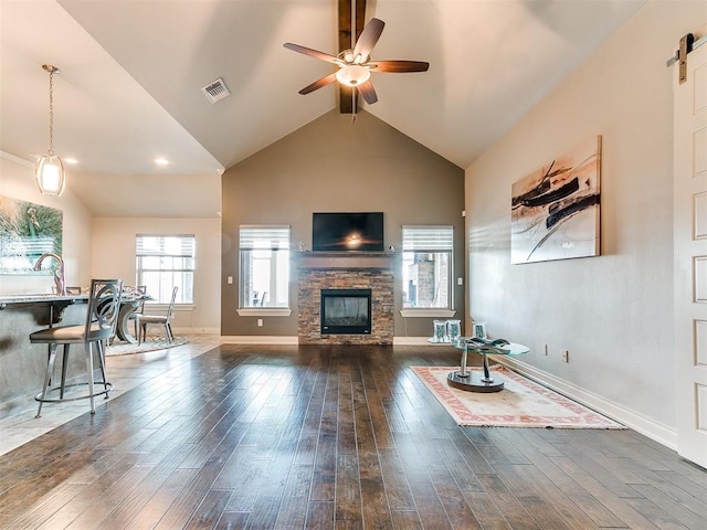 living room with a fireplace, a ceiling fan, dark wood finished floors, and visible vents