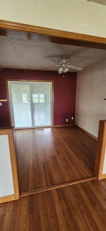 unfurnished room featuring ceiling fan, wood finished floors, and baseboards