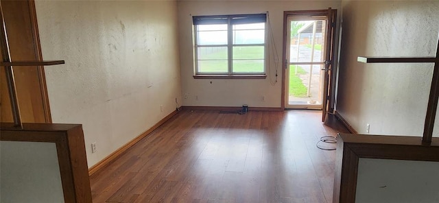 spare room with wood finished floors and baseboards