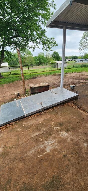 entry to storm shelter featuring fence