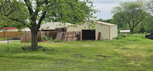 view of pole building featuring fence and a lawn