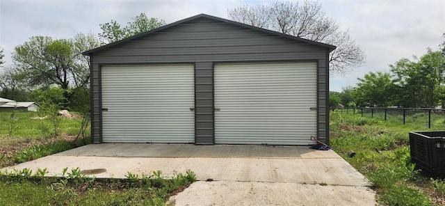 detached garage featuring fence