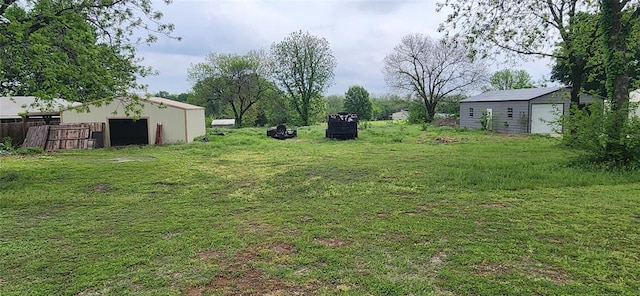 view of yard with fence and an outbuilding